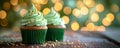 Decorated green cupcakes with cream and icing on blurred background. Food for holidays, birthday, weeding