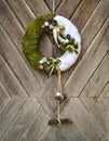 Decorated handmade Christmas wreath hanging on the rustic wooden door