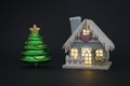 Decorated house in New Year\'s style and a green fir tree on a black background Royalty Free Stock Photo