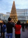 Decorated huge Christmas tree, lights, decorations, hot wine, hot chocolate, presents and people wandering at the Christmas market