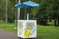 Decorated lemonade stand in park. Summer refreshing natural drink. White lemonade stall with tent and cranes. White street stall