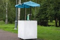 Decorated lemonade stand in park. Summer refreshing natural drink. White lemonade stall with tent and cranes. White street stall