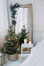 Decorated mirror and live Christmas tree with lights. New year's interior, festive atmosphere, decor, garlands