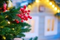 Decorated with mistletoe and baubles Christmas tree near a retro wooden house. Preparing for the new year and Christmas Royalty Free Stock Photo