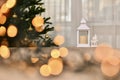 New Year`s Christmas composition, Christmas tree, candle lantern and porcelain white house in fairy-tale warm lights Royalty Free Stock Photo