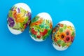 Decorated Paschal chicken eggs on blue background. Easter colored gift card
