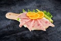 Decorated pizza ham sliced and vegetables on kitchen board with Royalty Free Stock Photo
