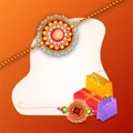 Decorated rakhi with gift box and shopping bag on shiny orange b Royalty Free Stock Photo