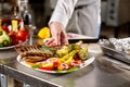 Decorated with a sprig of rosemary. the chef prepares in the restaurant. Grilled rack of lamb with fried potatoes and Royalty Free Stock Photo