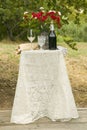 Decorated table with bottle of red wine, glasses and bouquet of flowers at a traditional Jewish wedding in Ojai, CA