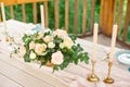 Decorated table for dinner for two person, with plates knife, fork, cheese, wine, wine glasses and flowers in a copper vase Royalty Free Stock Photo