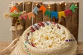 Popcorn served in a straw hat with party june decoration in the background. Festa Junina: Typical Brazilian June party. Closeup. Royalty Free Stock Photo