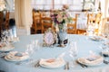 Decorated tables in sky-blue color with silver vase on the centre