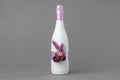 Decorated wedding bottle of champagne on gray backdrop. Royalty Free Stock Photo