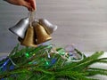 Decorating the Christmas tree: Christmas garland and golden and silver bells. Royalty Free Stock Photo
