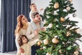 Decorating christmas tree. Family celebrating new year with their children at home Royalty Free Stock Photo