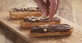 Decorating eclairs with hazelnuts on wood board Royalty Free Stock Photo