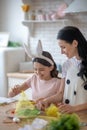 Sweet girl wearing easter bunnys ears decorating easter bun in her hands