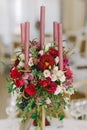 A graceful bouquet of fresh flowers and a candle on a wedding table.