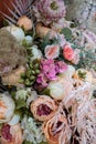 Decoration of artificial colors of nude shades, roses, cloves, ranunculus and green twigs with leaves