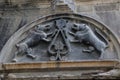 Decoration of a bas-relief with two mirror stone dogs on the facade of a medieval house in the historic center of the old city