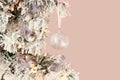 Decoration on Christmas tree - light violet birds and glassy ball on snowy spruce against pink background. Closeup Royalty Free Stock Photo