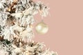 Decoration on Christmas tree - white birds and silver ball on snowy spruce on light pink background. Closeup Royalty Free Stock Photo