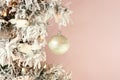 Decoration on Christmas tree - white birds and silver ball on snowy spruce on light pink background. Closeup Royalty Free Stock Photo