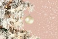 Decoration on Christmas tree - white birds and silver ball on snowy spruce on light pink background with snow mist. Closeup Royalty Free Stock Photo