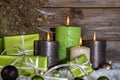 Decoration: four green and brown burning advent candles for christmas with presents. Royalty Free Stock Photo