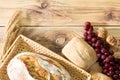 Decoration of fresh bread in the form of bread and rolls and bunches of dark grapes and ripe rye ears. Background from