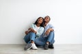 Decoration and furniture concept. Happy african american couple sitting on floor in new appartment, planning interior Royalty Free Stock Photo