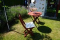 Wooden table and chairs stand on the lawn in the garden against the background of purple lavender flowers. Berlin, Germany Royalty Free Stock Photo