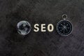 Decoration globe, alphabet SEO and compass on dark cement chalkboard background using as SEO Search engine optimization concept Royalty Free Stock Photo