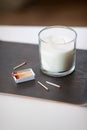 Fragrance candle and matches on tray on table
