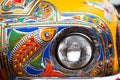 Colorful fish on headlight of pakistani truck