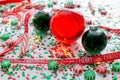 Decoration with red fluid filled Christmas ornament ball and two green filled ornament balls surrounded by a red Have Yourself A M