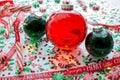 Decoration with red fluid filled Christmas ornament ball and two green filled ornament balls surrounded by a red Have Yourself A M