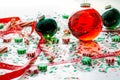 Decoration with red fluid filled Christmas ornament ball and two green filled ornament balls surrounded by a red Have Yourself A M