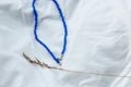 Decoration on a thread with blue stones, folk ethnic style on a linen shirt.