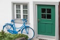 The decoration of vintage bicycle and white building with green door. Old blue retro bike and holiday house background Royalty Free Stock Photo