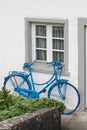 The decoration of vintage bicycle and white building with green door. Old blue retro bike and holiday house background Royalty Free Stock Photo