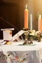 Decoration on the wedding table with candle, Rose vase,book, pen in Christian marriage. Wedding ceremony in christian church Royalty Free Stock Photo