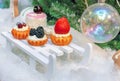 Decorations in the form of a variety of cakes on the background of the Christmas tree