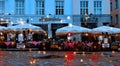 Pink Umbrella on Street cafe evenin wet asphalt coral on wet rain drops evening light Rainy Autumn relax in Old Town empty ci