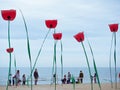 Decorations in the shape of giant poppies on the seashore at the