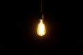 Decorative antique edison style light bulb glowing in the dark Royalty Free Stock Photo