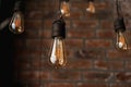 Decorative antique edison style light tungsten bulbs against brick wall Royalty Free Stock Photo