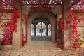 Decorative arched iron gateway through brick door to a garden Royalty Free Stock Photo