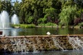 Decorative artificial pond with a fountain and a cascading waterfall. Royalty Free Stock Photo